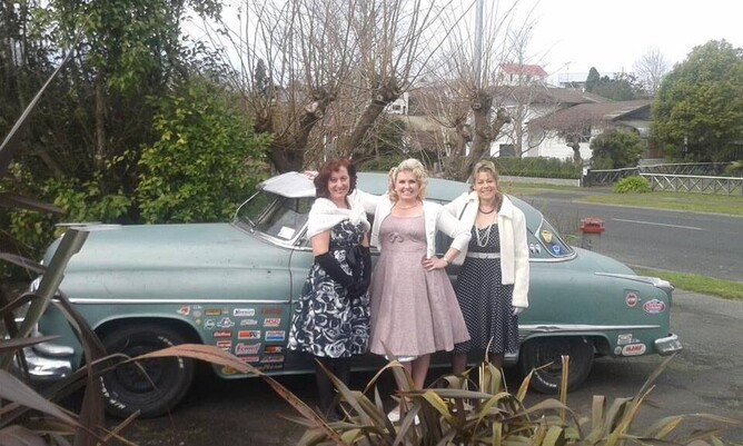 three wmen dressed up 1950s style with car