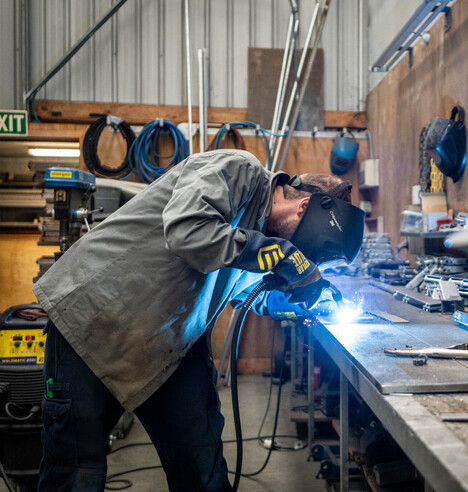 cream residential garage door with white trimming, and light grey weatherboard