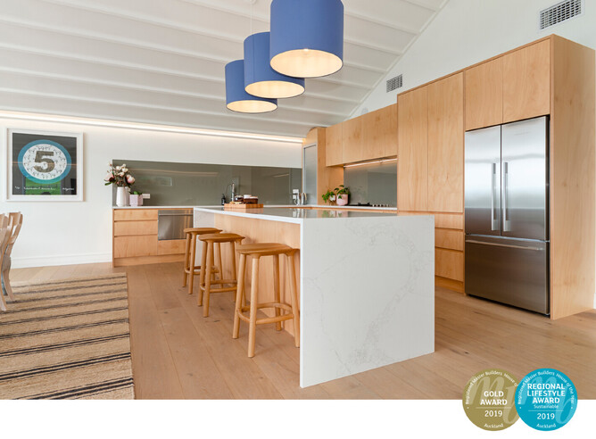 Kitchen of country home with plywood cabinetry and stone island bench