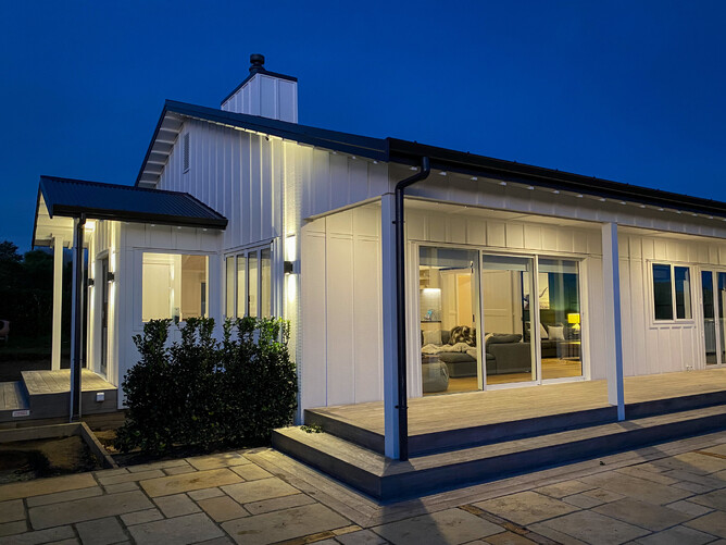 Country home at night with exterior lighting