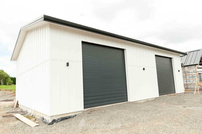 Ply board and batten storage barn painted white with colour steel roof