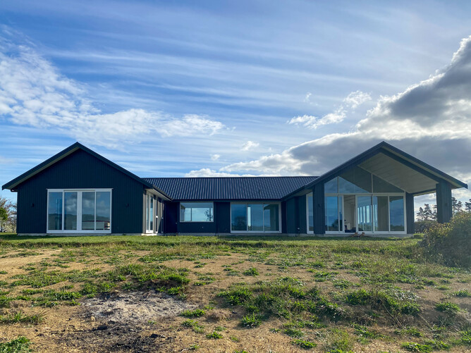 Exterior view of country home with two gables and black cladding