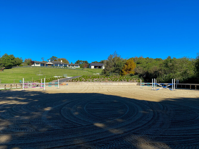 A view of the arena looking up at the home and barn on the hill