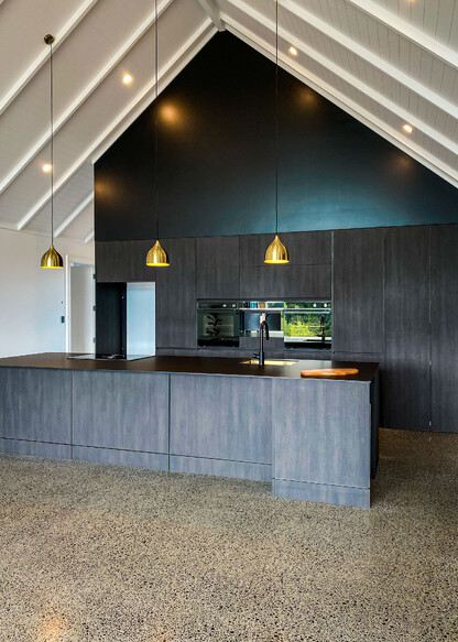 Dark kitchen with metallic pendants