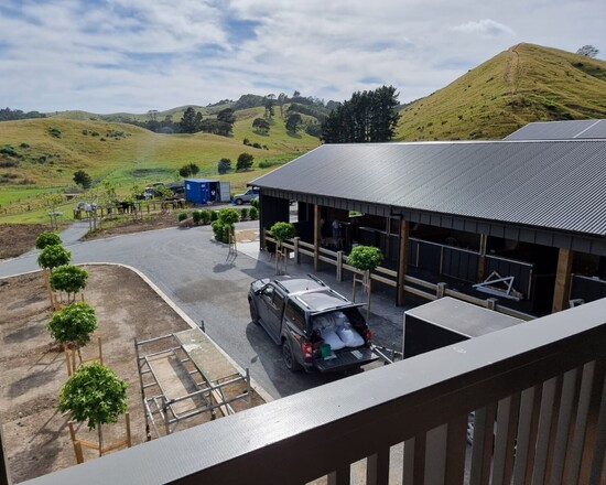 A view from the deck of a barn with integrated stables and apartment, looking down onto the stables