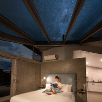 Stargazing from bed beneath the glass roof at SkyScape