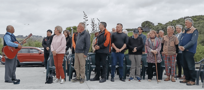 Image of people gathering for the blessing of the new secure garage and storage shed at CUE Haven's community forest.
