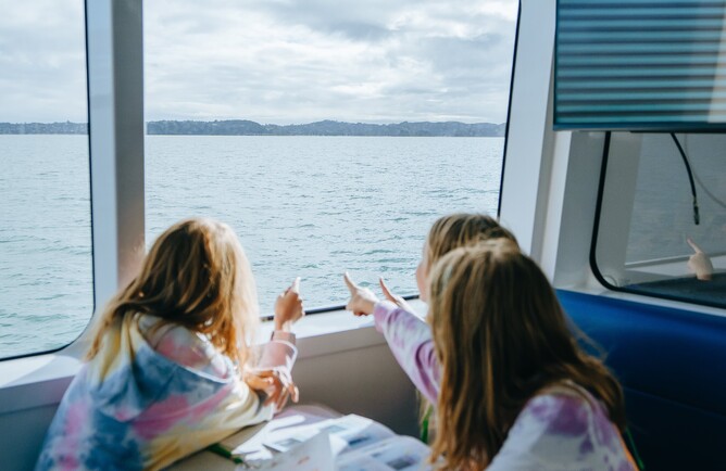Image of three girls on the ferry ride back from Rotoroa Island’s Education Programme. Supported by The Jenkins Foundation. New Zealand.