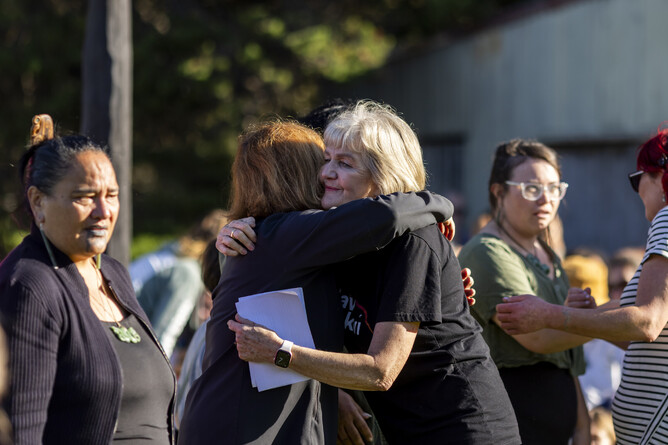 People gather and hug after an emotional welcome at the marae before the Kiwis are released at Waiheke Island in May 2025.