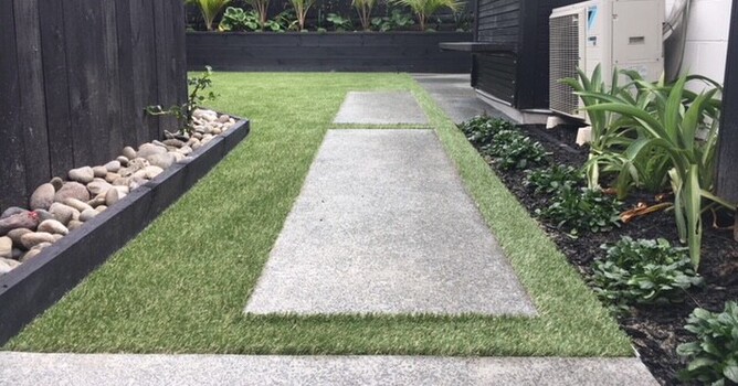 Concrete pavers creating a path through an area of fake grass