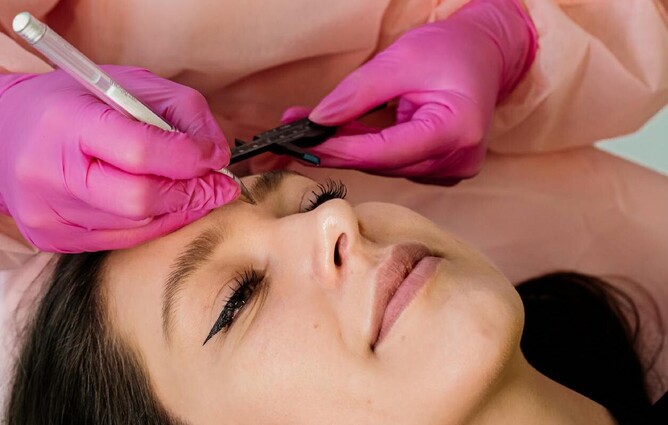 PERSON GETTING COSMETIC TATTOOING ON EYEBROWS