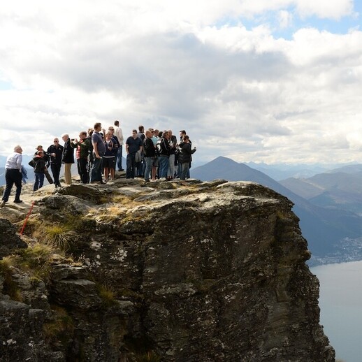 Conference attendees enjoying a helicopter trip to a ledge on a mountain in Queenstown.