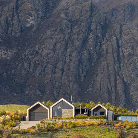 A front view of a stunning architectural home with schist, and cedar in Jacks Point.