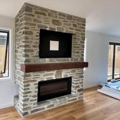A beautiful stacked stone inbuilt fireplace with timber mantel, and inbuilt tv.