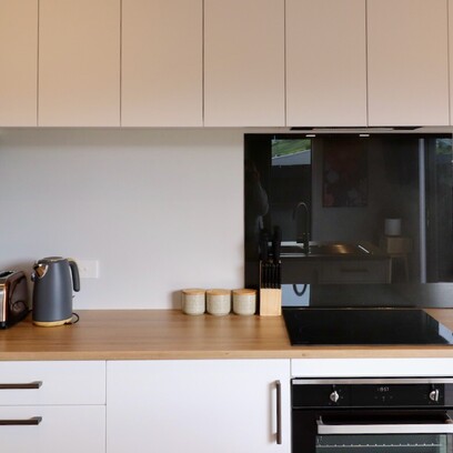 A light and bright kitchen with timber bench tops, and white cabinetry.