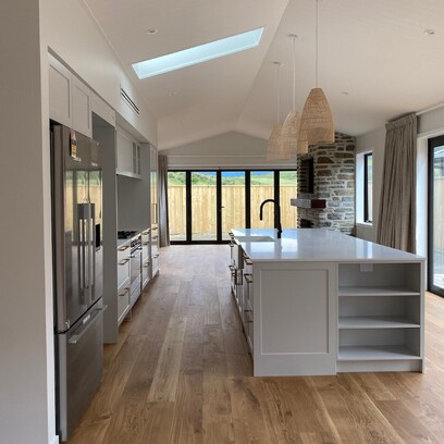 Looking out into the kitchen with large kitchen island, timber floors and skylight allowing lots of natural light in.