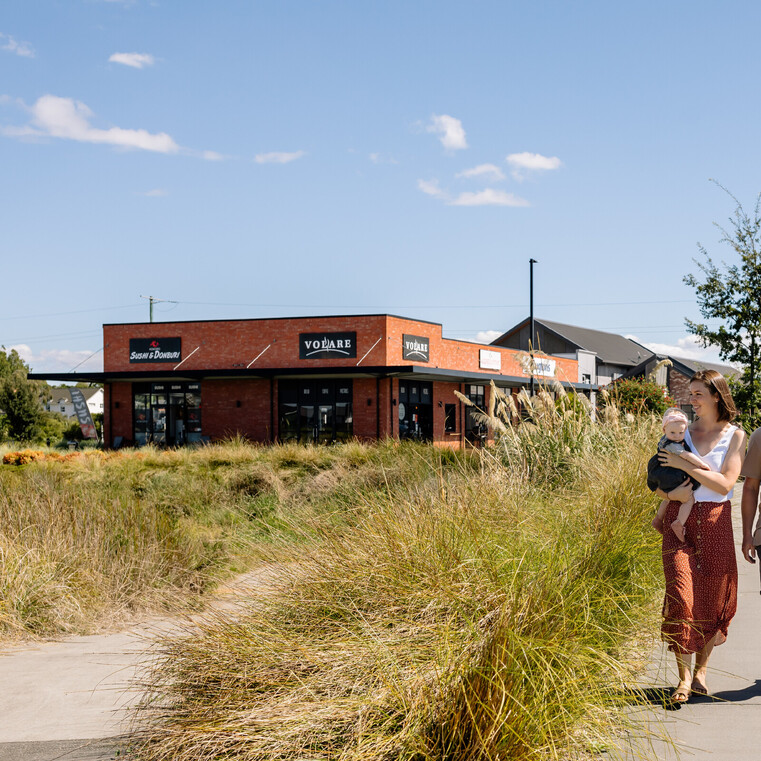 couple walking on pathway with Cafe building in the background