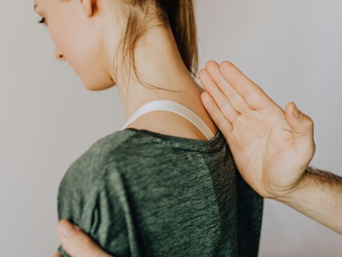 Picture for a young girl sitting and the osteopath putting his hand on her back showing her spine