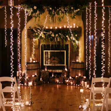 Winter wedding inspiration photo from Kumeu Valley Estate fireplace with flowers and curtain lights