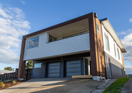 New home renovation in Papamoa by Local Builders, Straight Up Builders Tauranga. The image shows the completed property with enclosed deck area, new roof, new joinery, and new cladding.