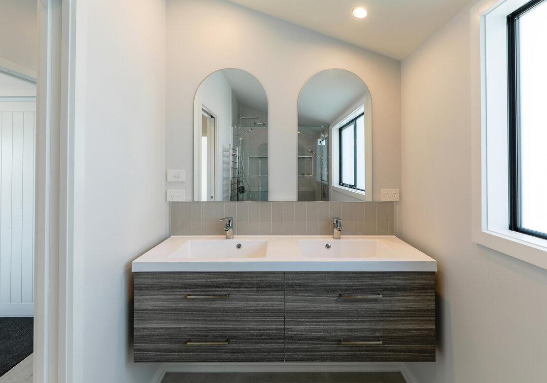 The image shows a new double sink and vanity, along with a double mirror, in this new bathroom fitout in Papamoa.