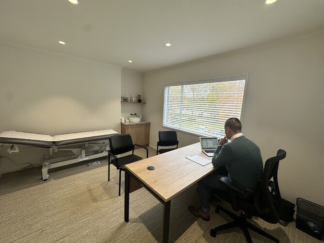 Clinician working at a desk inside Omnia Clinic’s modern, light-filled workspace.