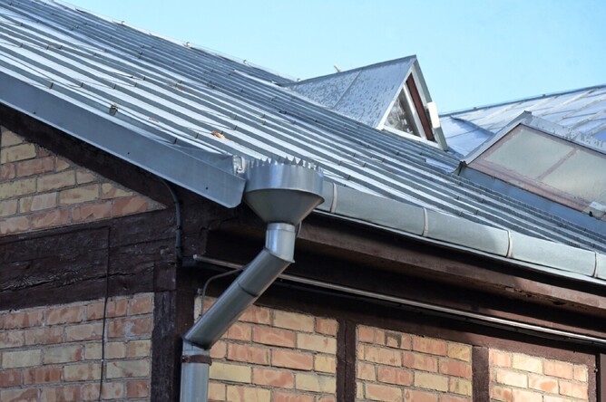 A metal roof with metal spouting.