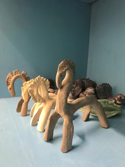 image of 4 ceramic horses on a blue shelf