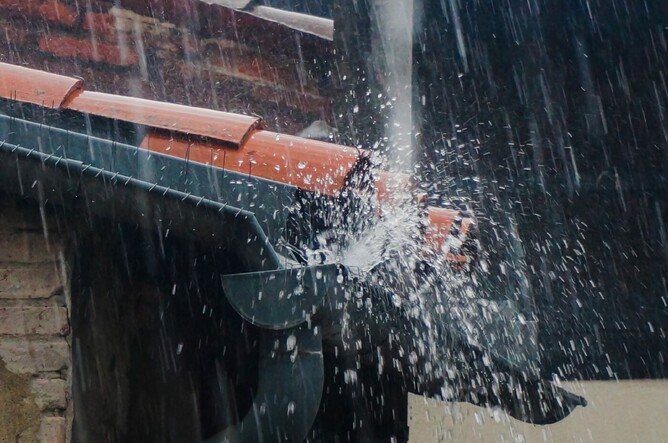 overflowing guttering in a downpour