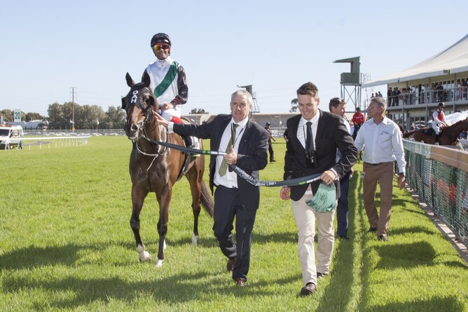 Sean Kiernan gives a thumbs up as he leads Fanatic and rider Michael Walker back to scale with son Jack. - Atkins Photography