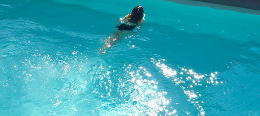 Beautiful swimming pool with swimmer coming up for a breath