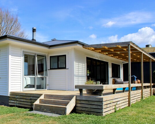 Image of white weatherboard home with new outside decking. Renovated by Coull Builders. Otorohanga, Waikato.