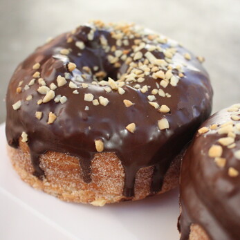 Cronut with chocolate icing and kibbled nuts