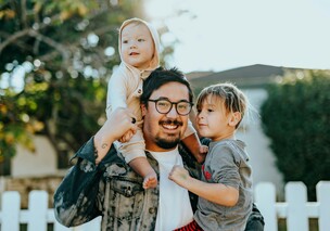 Smiling dad holding 2 children on his shoulders