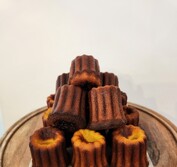 A pile of Caneles. caramelized outsides and fudgy centers.