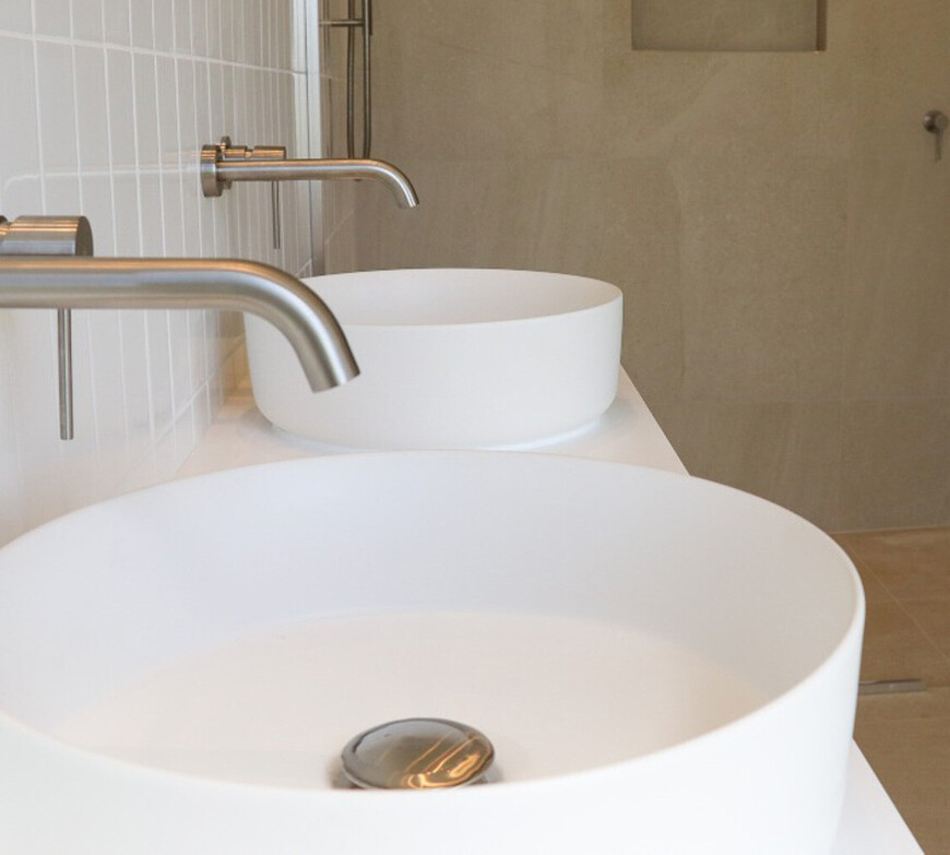 Image of Gane Plumbing's work. White round basins with tapware and tiled splashback.