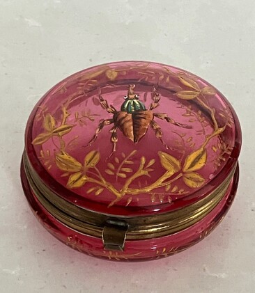 Antique cranberry glass vanity container featuring enameled insect and foliage