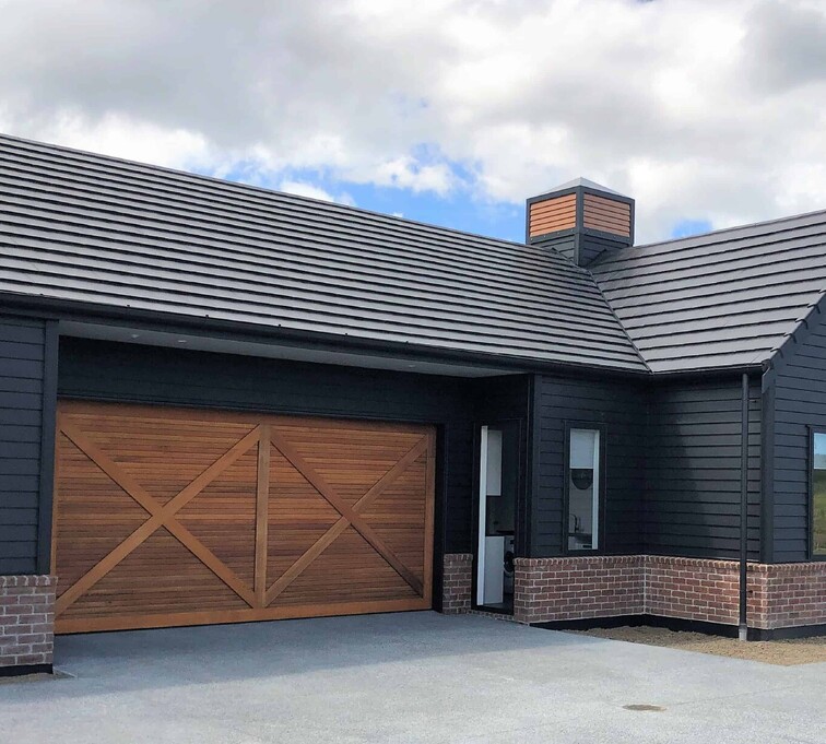 Photo of a timber garage door installed on a modern home in Rodney, Auckland NZ.
