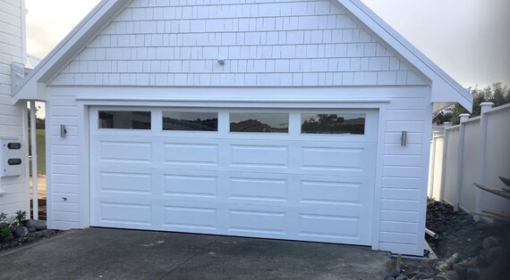 Photo of a white Somerset garage door with double press somerset windows. The double press insert windows match the Somerset's rectangular pressings.