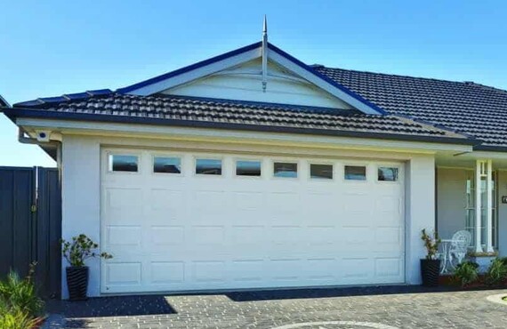 Photo of a white Georgian garage door with single press georgian windows. The single press insert windows match the Georgian's almost square pressings.
