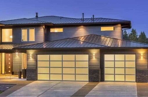 Photo of a modern home with VL designer panels fitted to a double garage and a single garage. Double garage glass panels are in a 4X4 grid, single garage has a 3X4 grid.
