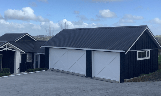 Photo of a custom double garage door and single garage door at new build home in rural Silverdale
