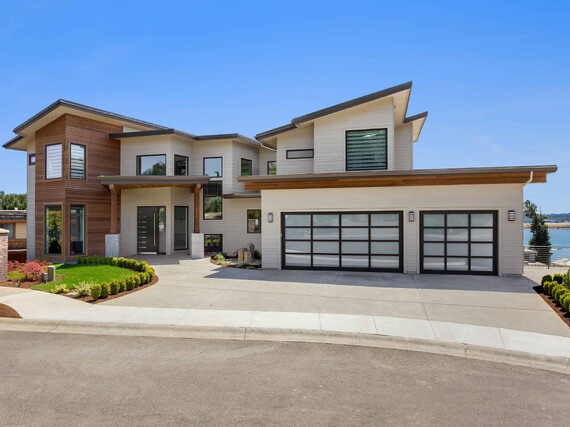 Photo of a modern home with VL designer panels fitted to a double garage and a single garage. Double garage glass panels are in a 4X4 grid, single garage has a 3X4 grid.