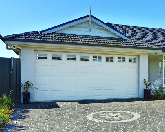 Photo of the Dominator Georgian Sectional garage door, upgraded with garage door windows