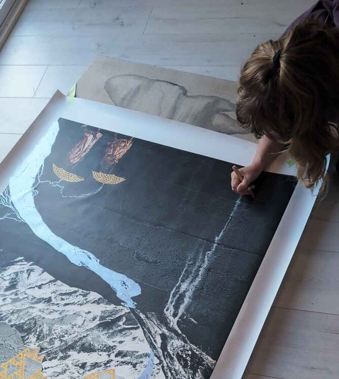 Sofia Minson signing some New Zealand Artwork she created