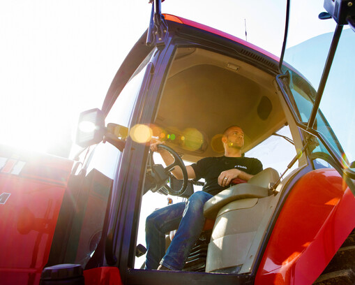 Farmer inside a Trimble-equipped tractor cab, operating precision guidance technology.