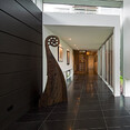 Paunui house, expansive hallway, with dark tiles and Koru statue