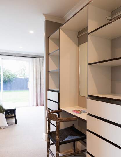 Fitted wardrobe with a make-up desk and mirror.