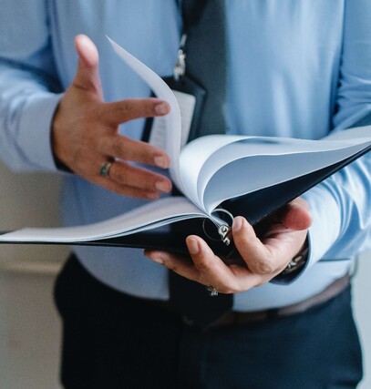 Man holding a binder and flipping through the pages