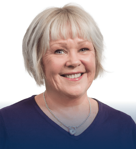 Professional headshot Julia, wearing a silver necklace and a purple top, smiling warmly against a plain white background